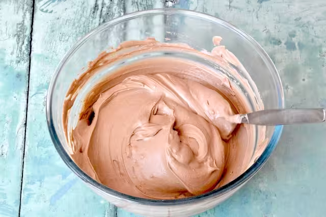 Roasted green tea yoghurt and double cream mix in bowl with spoon.