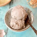 Homemade hojicha ice cream scoops in bowl with spoon.