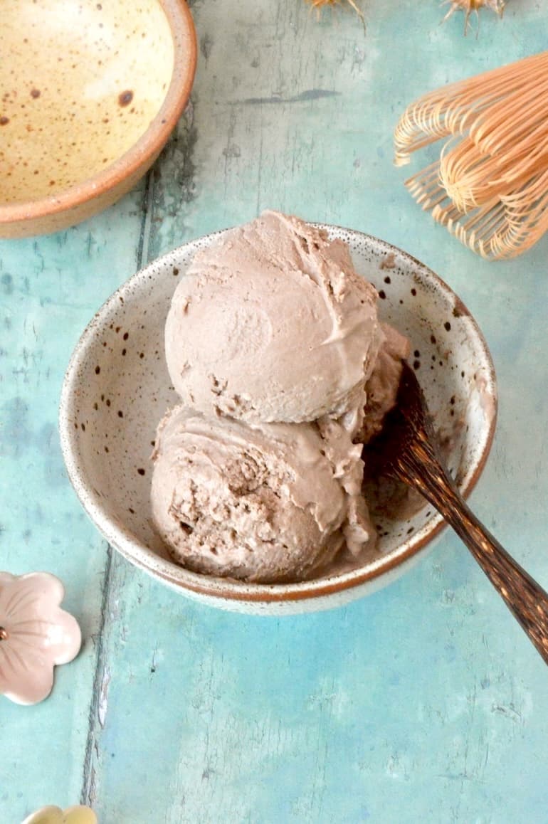 Homemade hojicha ice cream scoops in bowl with spoon.