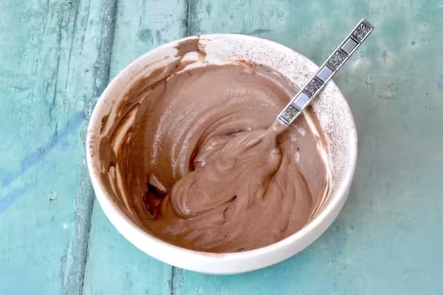 Bowl of mixed hojicha powder and Greek yoghurt with spoon.