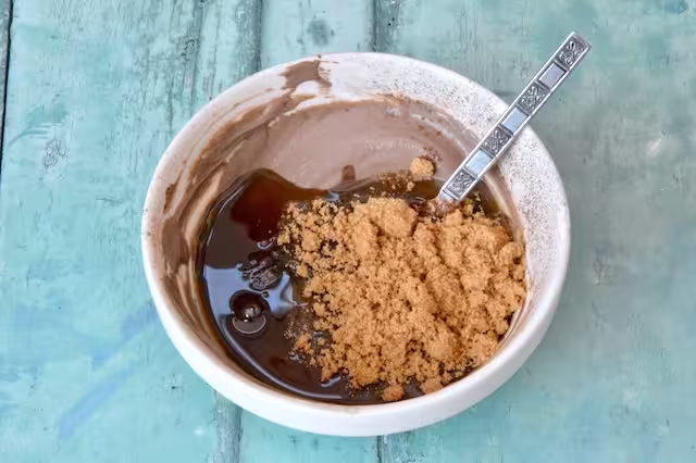 Honey and brown sugar added to tea and yoghurt mix in bowl.