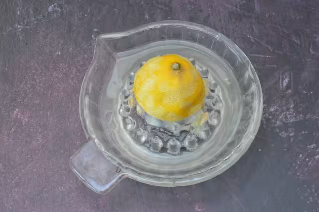 Extracting juice from half zested lemon.