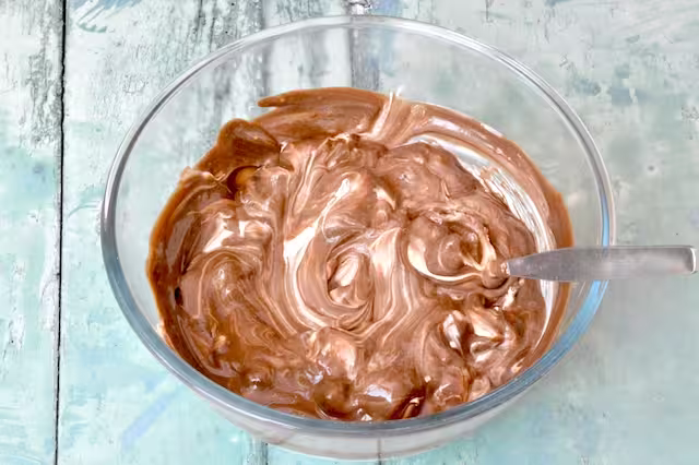 Stirring roasted green tea yoghurt into whipped double cream.