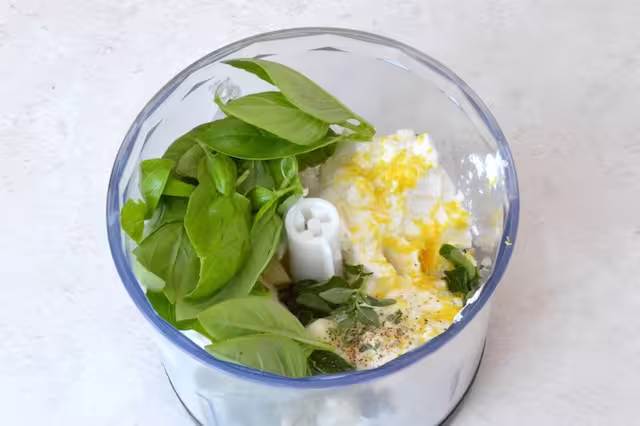 Whipped ricotta ingredients in food processor bowl.