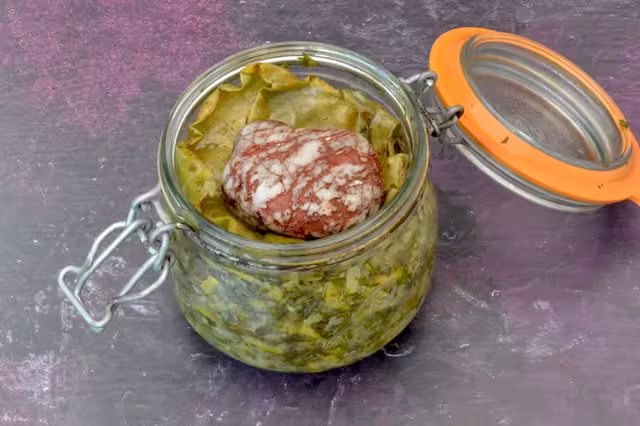 Open ferment jar with pebble on top.