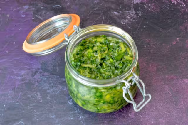 Vegetables and juice packed into jar.