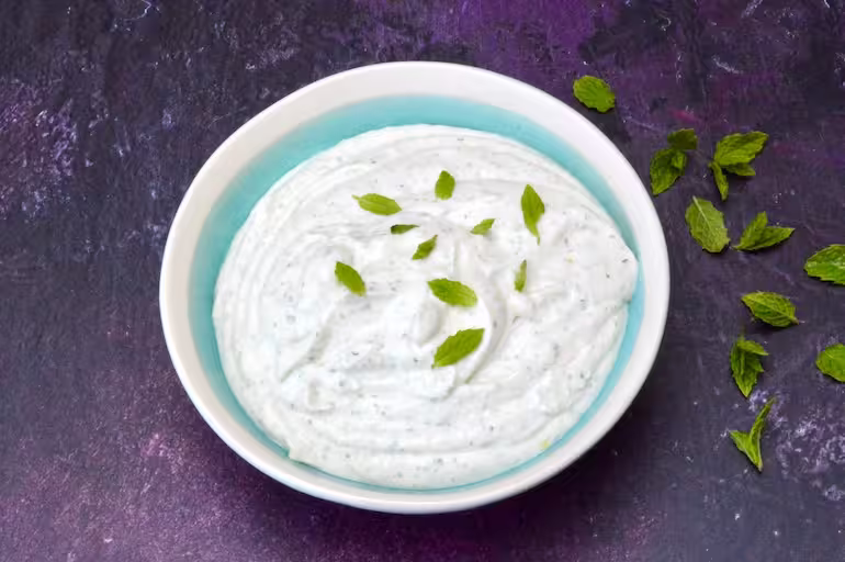 Whipped cottage cheese in bowl with mint leaves.