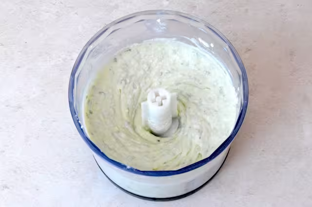 Whipped ricotta in food processor bowl.