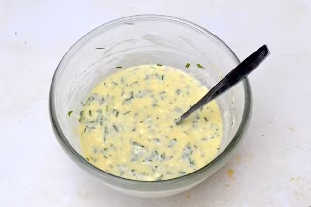 Beaten egg mixture in mixing bowl with fork.