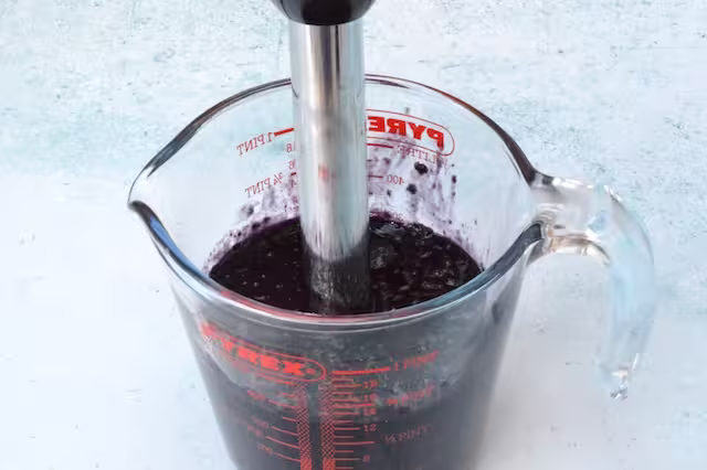 Blackberries blended in jug with stick blender.