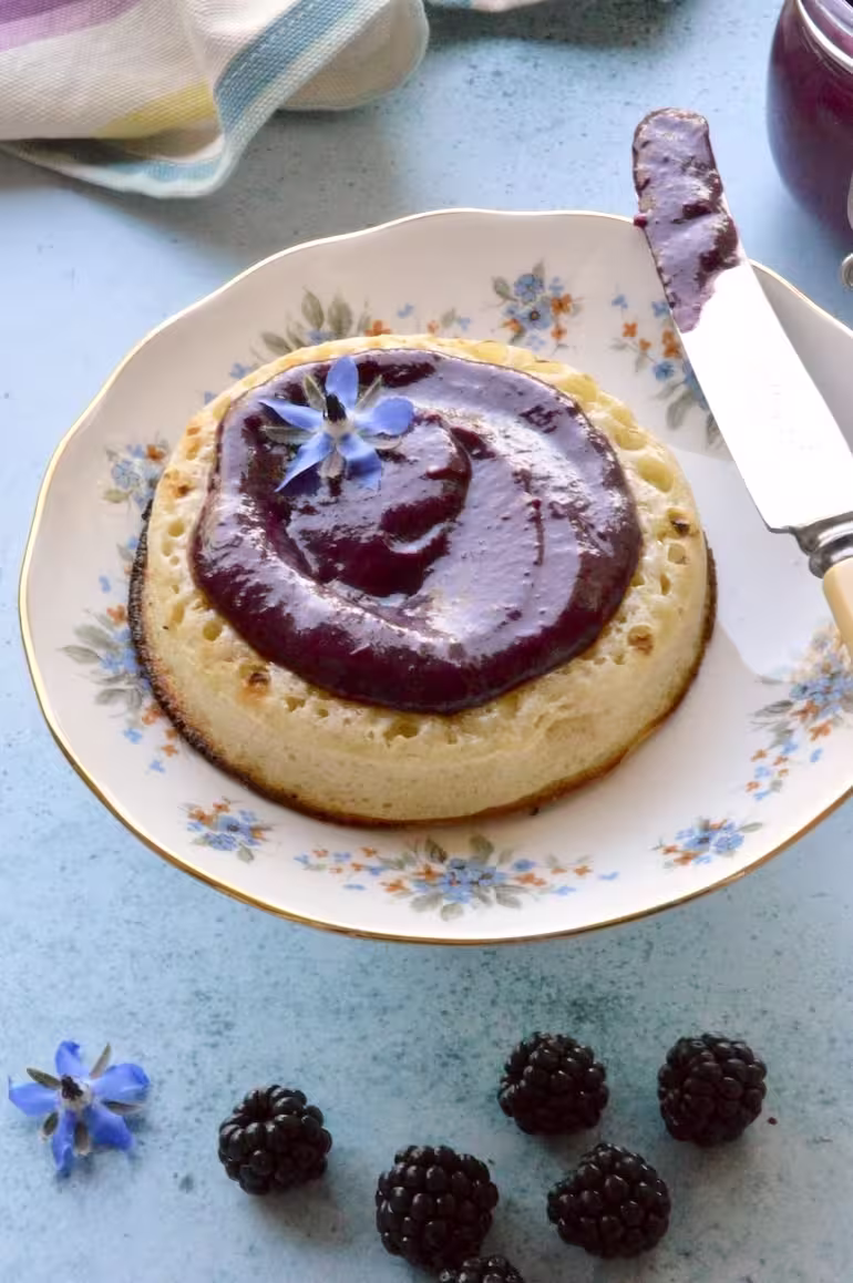 Toasted crumpet spread with homemade blackberry curd.