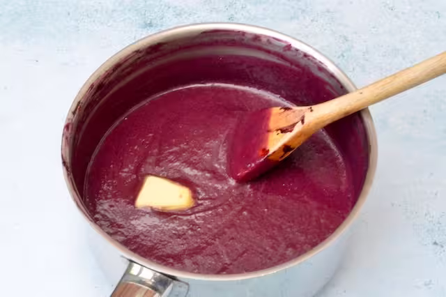 Butter added to pan of blackberry curd.