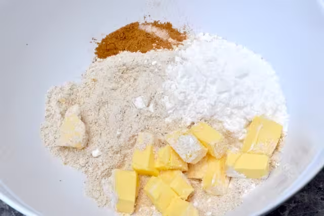 Butter cubes, flour, icing sugar and cinnamon in mixing bowl.