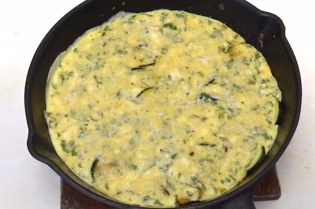 Eggs almost set in cast iron pan and cheese grated on top.