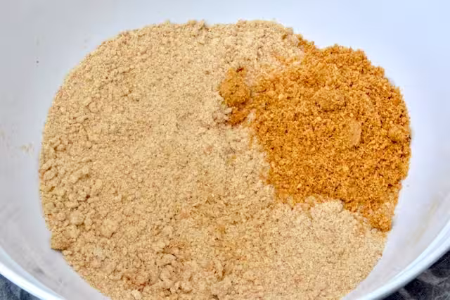 Ground hazelnuts added to flour mixture in bowl.