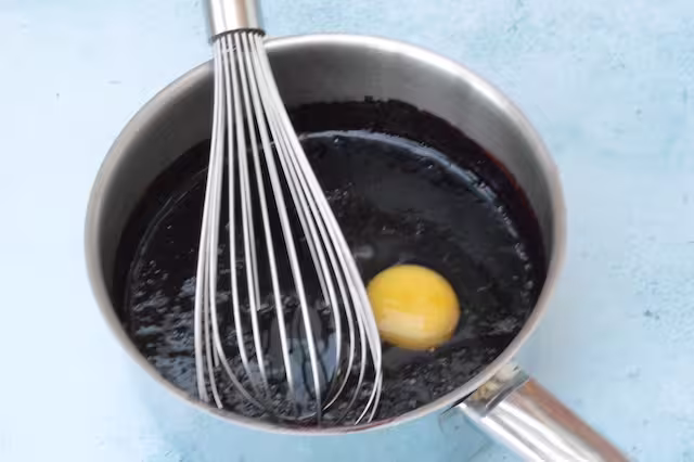 Whisking eggs into fruit puree.