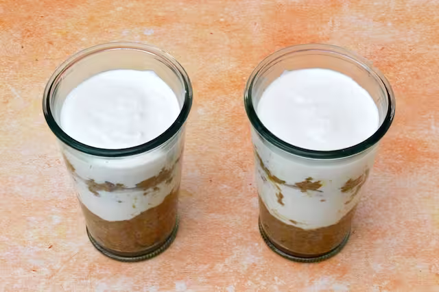 Two glasses with fourth layer of breakfast tiramisu added.