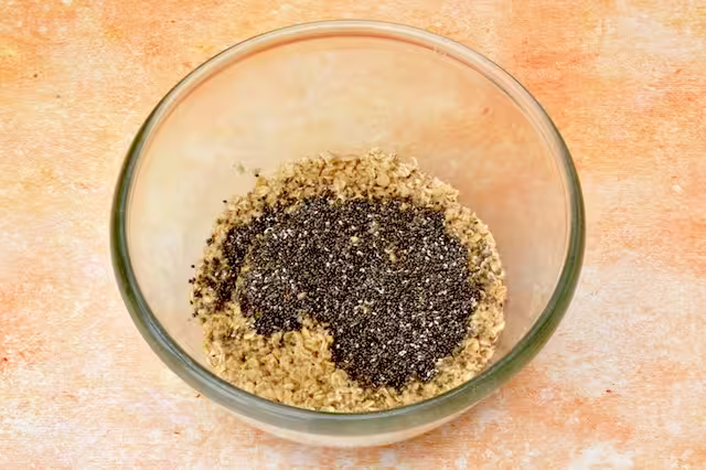 Chia seeds added to oat soak in mixing bowl.