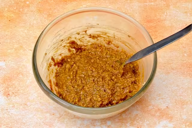 Final mix of soaked oats in mixing bowl with spoon.