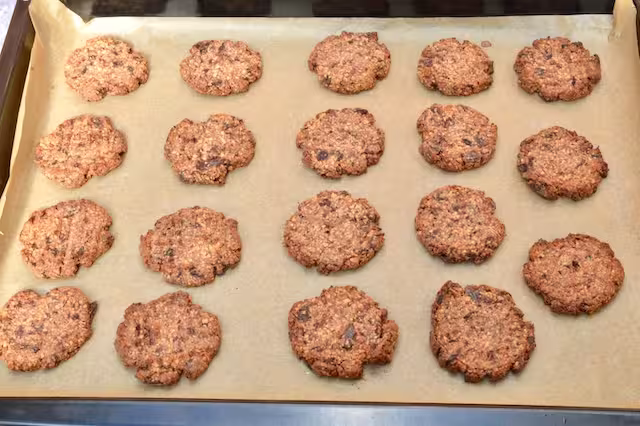 Baked date and almond cookies on baking sheet.