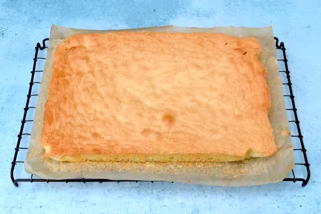 Genoise made with plain flour cooling on wire rack.