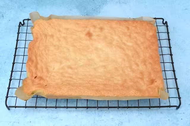 Baked genoise sponge on cooling rack.