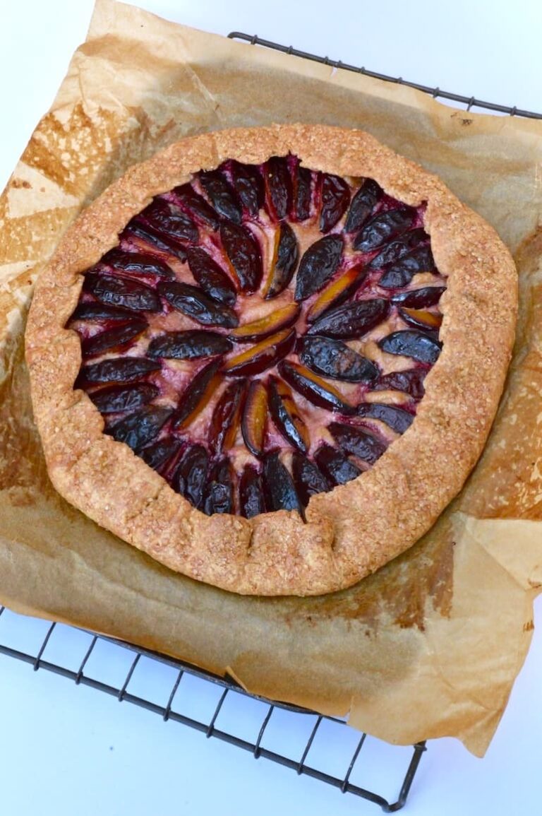 Plum ricotta galette with wholemeal spelt flaky pastry cooling on baking paper and wire rack.