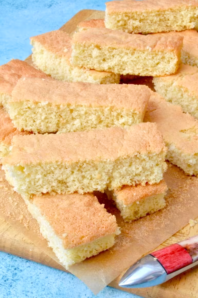 Freshly baked homemade trifle sponges piled on a board.