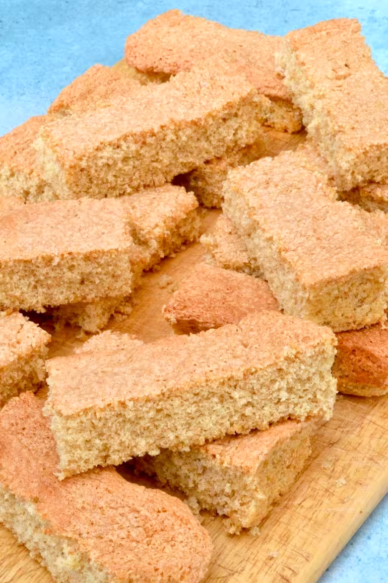 Homemade wholemeal spelt trifle sponges piled on a board.