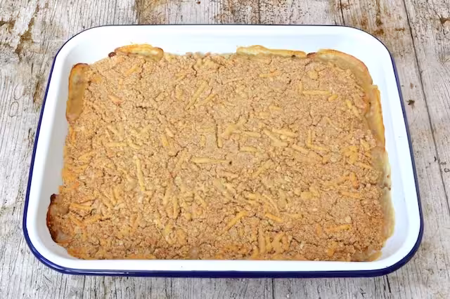 Baked leek and bean crumble with cheesy topping just out of oven.
