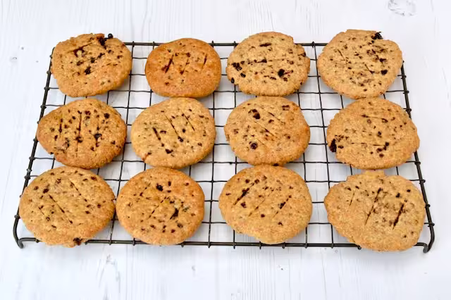 Baked Chorley cakes cooling on wire rack.