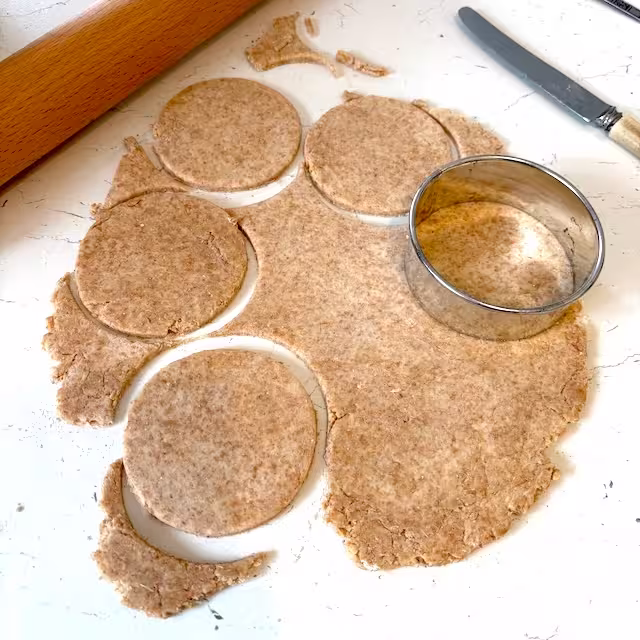 Stamping pastry circles with a ring cutter.