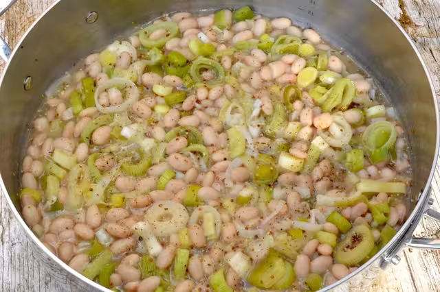 Leeks and beans in pan ready to go into baking dish.
