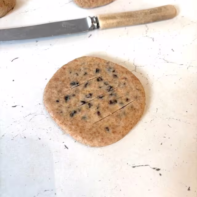Raw Chorley cake scored with slashes.