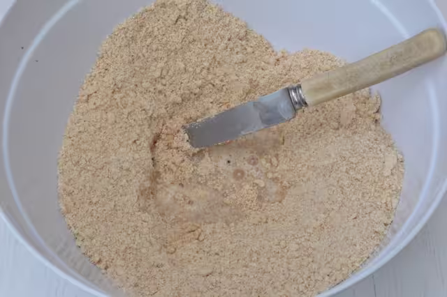 Water added to flour and butter breadcrumbs in bowl with knife.